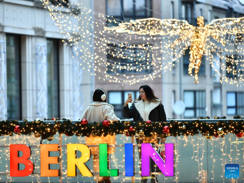 Du khách chụp ảnh lưu niệm giữa không gian Giáng sinh rực rỡ ở Berlin, Đức. Ảnh: Xinhua