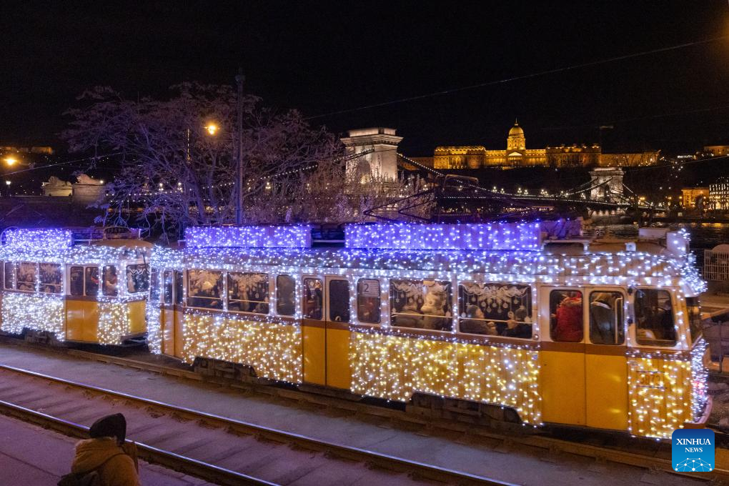 Chuyến tàu điện cổ được trang hoàng lộng lẫy chạy trên con đường ven sông Danube ở Budapest, Hungary. Ảnh: Xinhua